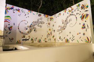 Una pared blanca con mariposas de colores. en Luxury Private Villas , Private Pool, Private garden, Jacuzzi, 24hours security, en Tulum