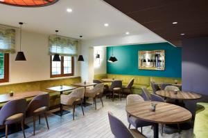 a dining room with wooden tables and chairs at Hôtel Maison Turenne in Colmar