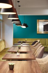 a row of tables in a restaurant with green walls at Hôtel Maison Turenne in Colmar