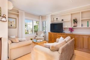 a living room with two couches and a flat screen tv at Casas Mari y Pili para 12 personas a unos 200 m de la playa in Portocolom