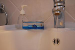 a bathroom sink with a soap dispenser and a bottle of water at BAY VIEW HOUSE in Megas Gialos - Nites +38 photos