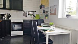 a kitchen with a table with chairs and a stove at Apartment Dreamvalley in Isfjorden