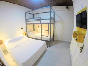 a bedroom with a bunk bed and a tv at Hostel da Milla in Presidente Figueiredo