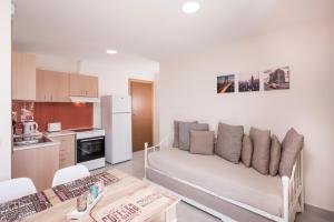 a living room with a couch and a kitchen at Athina Apartments in Plataniás