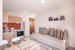 a living room with a couch and a kitchen at Athina Apartments Near The Sea Platania in Plataniás