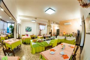 a restaurant with tables and chairs with green table cloth at Hotel Angelini in Rimini