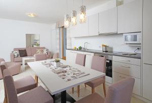 kuchnia i salon ze stołem i krzesłami w obiekcie Villa delle Querce w Tremosine Sul Garda