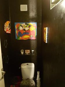 baño con aseo y una pintura en la pared en La Bikok en Billy