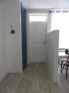 a hallway with a white door and a table and a dining room at L'Eau Reine in Saumur