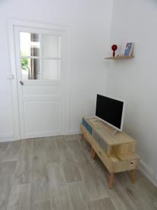 Pokój z biurkiem, telewizorem i drzwiami w obiekcie L'Eau Reine w mieście Saumur