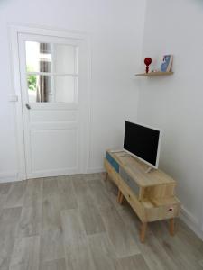 a room with a desk with a television and a door at L'Eau Reine in Saumur