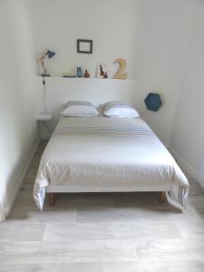 a bedroom with a large bed with white sheets at L'Eau Reine in Saumur