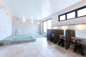 a large bathroom with a tub and a sink at HOTEL HILLARYS Shinsaibashi in Osaka +62 photos