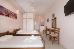 a bedroom with two beds and a table and chairs at Yiota Studios in Alykes