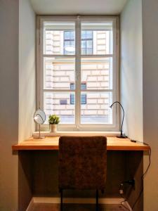 una ventana con escritorio y una silla frente a ella en St. Mark's Boutique Apartment Zagreb, en Zagreb