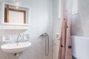 a white bathroom with a sink and a shower at Yiota Studios in Alykes +28 photos