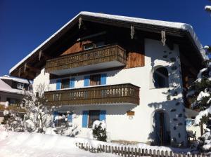 a house with a balcony in the snow at Haus Magnolia in Schwangau