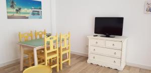 a small dining room with a table and a tv at Casa del Mar in Puerto Real