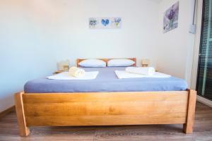a bedroom with a bed with two towels on it at Apartments and Rooms Skalinada in Murter