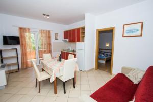 a kitchen and living room with a table and a couch at Apartments and Rooms Skalinada in Murter