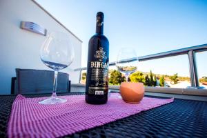 a bottle of wine sitting on a table with two glasses at Apartments and Rooms Skalinada in Murter