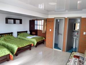 a bedroom with two beds and a bathroom at Paraíso Tropical - Hotel Campestre in Aguadas +33 photos