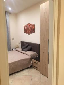Schlafzimmer mit einem Bett und einer Holztür in der Unterkunft Il Giardino di Daphne in Neapel