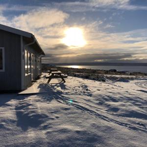 una mesa de picnic en la nieve junto a un edificio en Hvammstangi Hill Homes en Hvammstangi