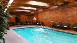 a large swimming pool with chairs in a building at Century Hotel in Tualatin