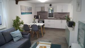 cocina y sala de estar con sofá y mesa en Ferienwohnung Frieda, en Hungen