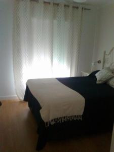 ネルハにあるApartamento Azulのベッドルーム1室(ベッド1台付)、窓(白いカーテン付)