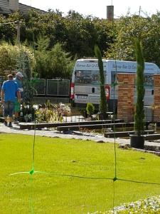 un hombre de pie en un patio con una furgoneta en el fondo en Barna Bár Motel&Apartman, en Tetélen