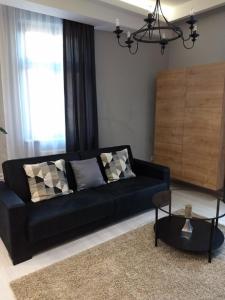 a black couch in a living room with a table at Apartament Kamea Wieliczka Centrum in Wieliczka