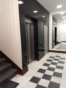 an empty hallway with elevators and a checkered floor at Apartament Kamea Wieliczka Centrum in Wieliczka