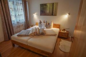 una camera da letto con un letto con lenzuola e cuscini bianchi di Apart Waldblick a Oetz