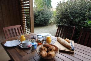 una mesa de madera con pan y zumo de naranja. en Domaine des Compouzines, en Montignac