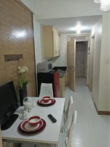 - une table blanche avec des plaques rouges dans la cuisine dans l'établissement CHATEAU ELYSEE a6 near AIRPORT Wifi Kitchen, à Manille