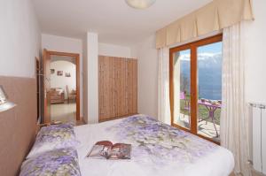 een slaapkamer met een bed en uitzicht op een balkon bij Villa delle Querce in Tremosine Sul Garda