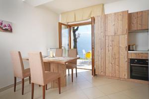 una sala da pranzo con tavolo e sedie e un balcone di Villa delle Querce a Tremosine Sul Garda