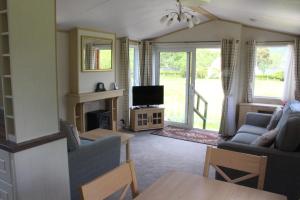 a living room with two couches and a television at Ben View in Taynuilt