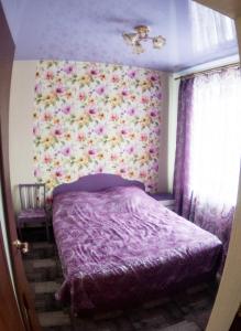 キロフスクにあるПарковая 3の花の壁のベッドルーム(紫色のベッド1台付)