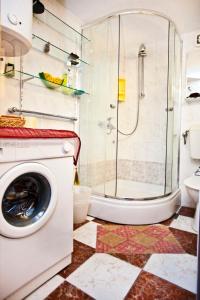 a bathroom with a shower and a washing machine at Split Apartments Peric in Split