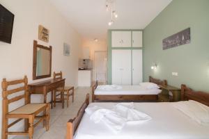a bedroom with two beds and a desk and a mirror at Yiota Studios in Alykes