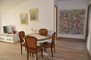 un comedor con mesa, sillas y una pintura en Can Valleta en Bot