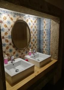 Baño con 2 lavabos y espejo en Goodnight Hostel, en Lisboa