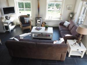 a living room with couches and a coffee table at De Vergulde Kikker in Baaiduinen