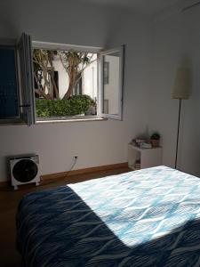 een slaapkamer met een groot bed en een raam bij In Cascais in Cascais