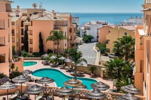 a view of a resort with a pool and umbrellas at Apartamento Boa Estrela in Luz