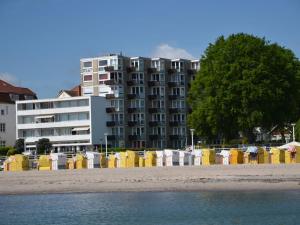 a beach with yellow and white barriers and a building at WellenRausch Living "Nock" in Travemünde