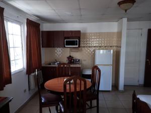 a kitchen with a table and a white refrigerator at Hotel California Panama in Panama City